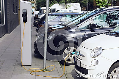 Recharge. Electric Car in Free Charging Station. Environmentally Friendly Transport Stock Photo