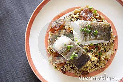 Cod loins cooked in the oven with quinoa and peach. Stock Photo