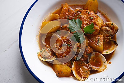Cod loins cooked in the oven with tomato and clams. Stock Photo