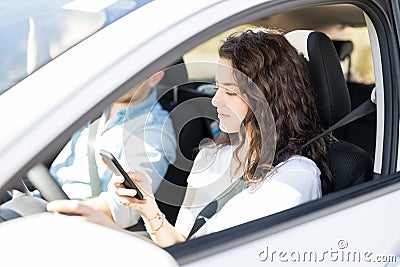 Reckless woman using phone while driving car Stock Photo