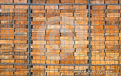 Reclaimed bricks stacked in a metal cage Stock Photo