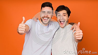 We recommend! Happy men showing thumbs up Stock Photo