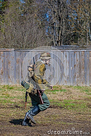 Reconstruction of the Second World War. A German soldier is running. Editorial Stock Photo