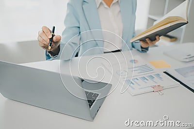 Recording various information on paper, Employees sit and take notes in the office, A businesswoman searches for information on a Stock Photo