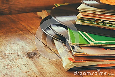 Records stack with record on top over wooden table. vintage filtered Stock Photo