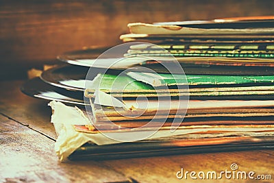 Records stack with record on top over wooden table. vintage filtered Stock Photo