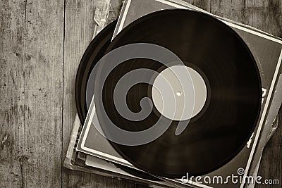 Records stack with record on top over wooden table. vintage filtered Stock Photo