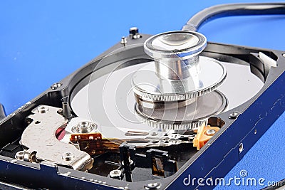 RECOVERY AND REPAIR TECHNOLOGY CONCEPT: Hard Disk Drive HDD with stethoscope isolated on a blue background. Stock Photo