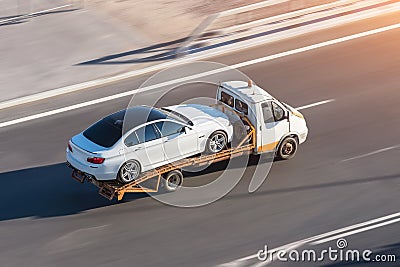 Recovery truck to transport a car on the highway in the city Stock Photo