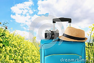 Recreation image of traveler luggage, camera and fedora hat infront of a rural lanscape. holiday and vacation concept Stock Photo
