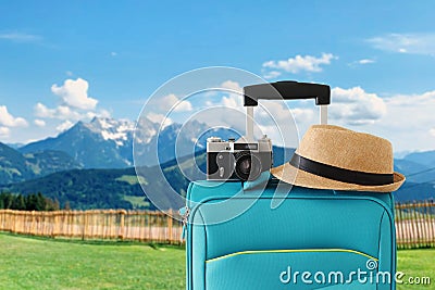 Recreation image of traveler luggage, camera and fedora hat infront of a rural lanscape. holiday and vacation concept Stock Photo