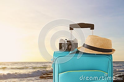 Recreation image of traveler luggage, camera and fedora hat infront of tropical sunset background. holiday and vacation concept Stock Photo