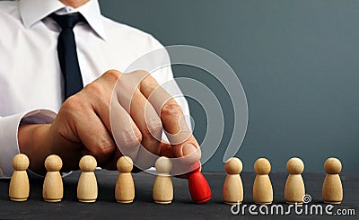 Recruiter choosing one figurine from the crowd. Talent management and hiring Stock Photo