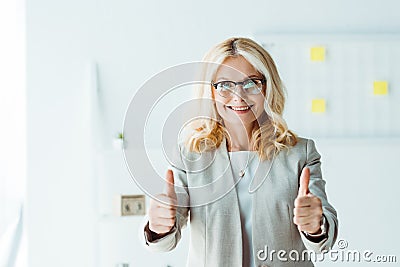 Recruiter in glasses showing thumbs up in office Stock Photo