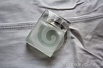 Rectangular perfume bottle on light grey jeans Stock Photo