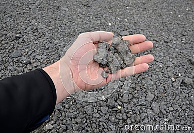 Recycled asphalt crumb is used on the edge of the new cycle path and in the subsoil of the asphalt road. between the field and the Stock Photo