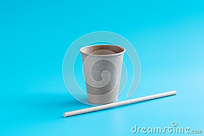 Recycled paper cup and drinking straw on blue background. Eco-friendly biodegradable drinkware. Zero waste concept Stock Photo