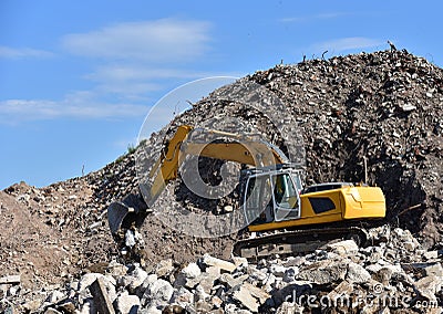 Recycling concrete and construction waste from demolition. Excavator at landfill of the disposa. Reuse of building rubble. Backhoe Editorial Stock Photo