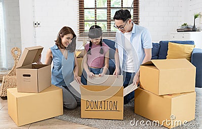 Recycling, Donation for poor, smiling asian family pack, holding donate box full with second hand clothes, charity helping and Stock Photo