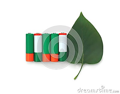 Recycling, energy, environment and ecology concept - close up of green alkaline batteries with leaf over white background Stock Photo