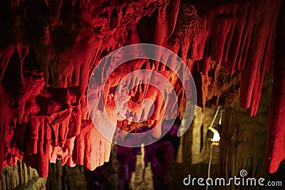 Red abstract background of stalactites, stalagmites and stalagnates in a cave underground, horizontal Stock Photo