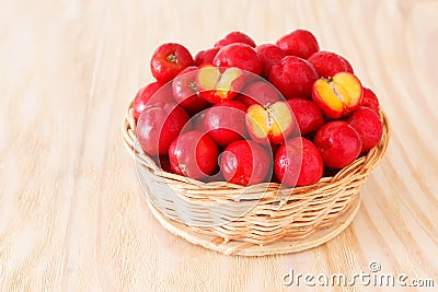 Red acerola - malpighia glabra, tropical fruit in wicker busket Stock Photo