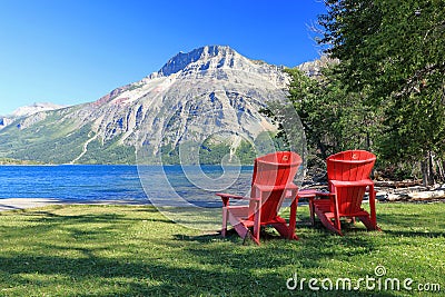 Canadian Rocky Mountains Landscape with Red Parks Canada Adirondack Chairs, Waterton Lakes National Park, Alberta Stock Photo