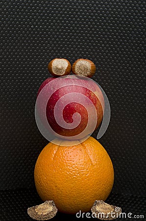 Red apple, hazelnut, Brazil nut and an orange on black Stock Photo