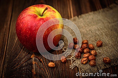 Red apple hazelnut on dark wooden background Stock Photo