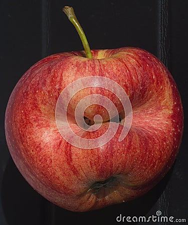 Red apple of irregular shape Stock Photo