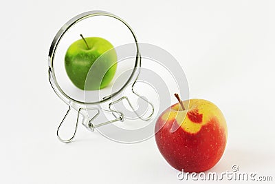Red apple looking in the mirror and seeing itself as a green apple - Concept of daltonism and color blindness Stock Photo