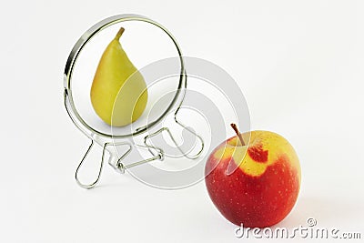 Red apple looking in the mirror and seeing itself as a pear - Concept of dysmorphobia and distorted self-image Stock Photo