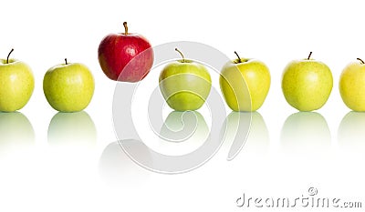 Red apple standing out from row of green apples. Stock Photo