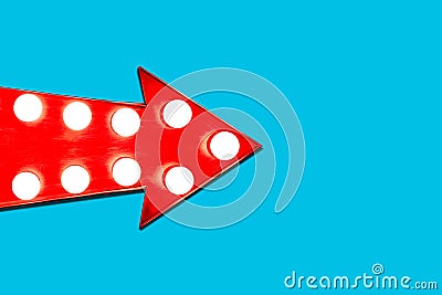 Red arrow shaped vintage colorful illuminated metallic display direction sign with glowing light bulbs pointing from left Stock Photo