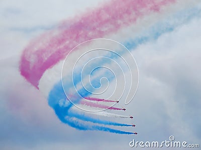 Red arrows air display with white smoke contrails Editorial Stock Photo