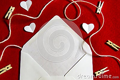 A red background from felt. A composition from heart, thread and clothespins. Frame from envelope for writing. Background with Stock Photo