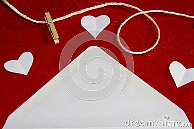 A red background from felt. A composition from heart, thread and clothespins. Frame from envelope for writing. Background with Stock Photo