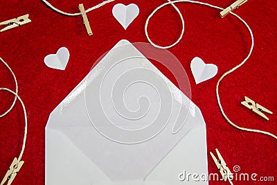 A red background from felt. A composition from heart, thread and clothespins. Frame from envelope for writing. Background with Stock Photo