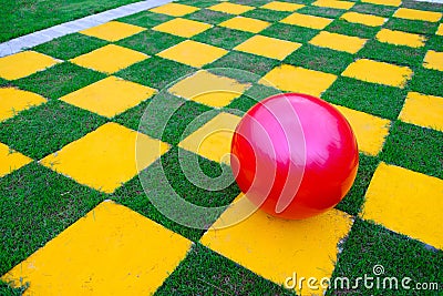 Red ball on yellow-green chess grid field Stock Photo