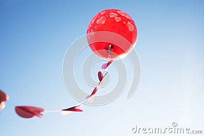 A little girl with red balloon on the blue sky. Stock Photo