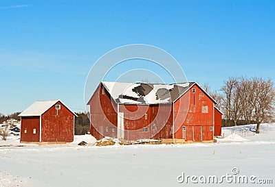 Red Barn and Outbuildings in Winter Countryside with Snow Stock Photo