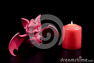 Red bat and burning candle. Mystical atmosphere witchcraft. Magic occult witch ritual. Esoteric concept Stock Photo