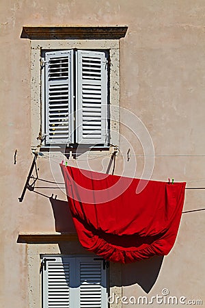 Red bedsheet hanging to dry Stock Photo