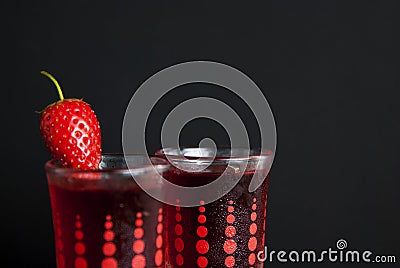 Red berries liqueur in shot glass isolated on black background and wooden table. Homemade alcohol drink concept. Stock Photo