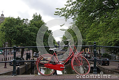 Red Bicycle on Amsterdam Bridge Over Canal Editorial Stock Photo