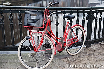 Red bike on bridge over gracht canal, Amsterdam Stock Photo