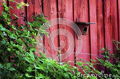 Red Bird House attached to Red Barn Stock Photo