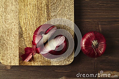 Red bisect onion on wooden table. Close-up from above. Stock Photo