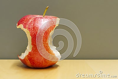 Red bitten apple in a table Stock Photo