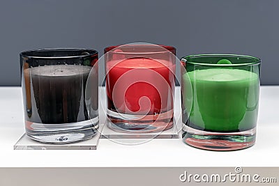 Red, black and green scented candles in transparent candlesticks Stock Photo